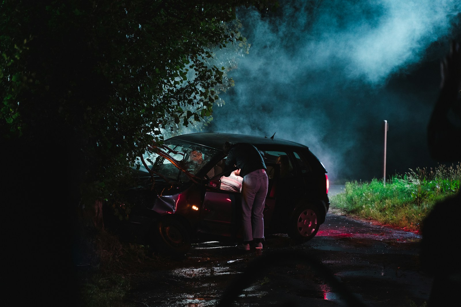 a person standing next to a car with smoke coming out of it auto